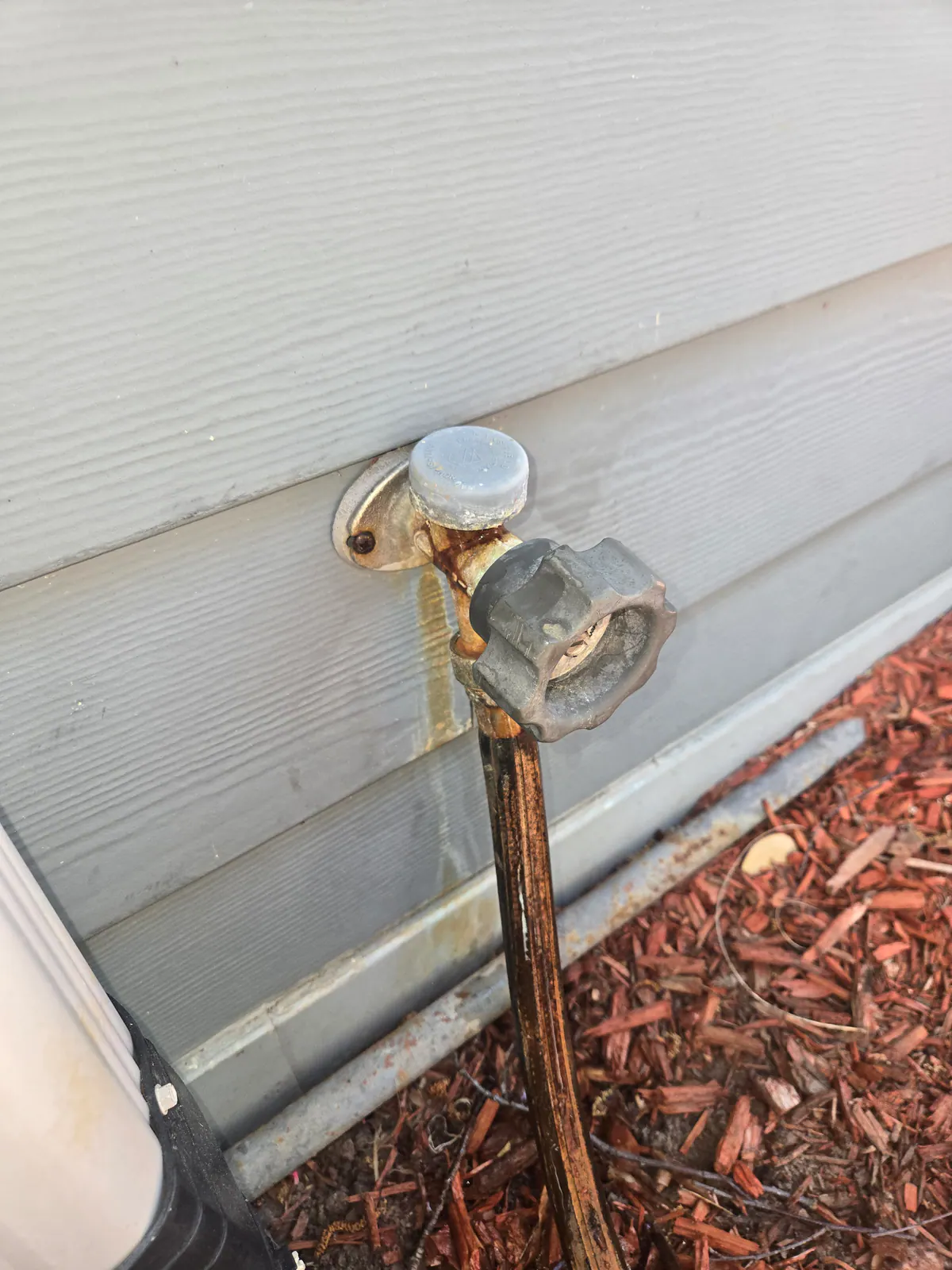 BEFORE: Old exterior hose bibb at a home in East Troy — by Jacob, O'Leary Plumbing, Heating & Electrical.