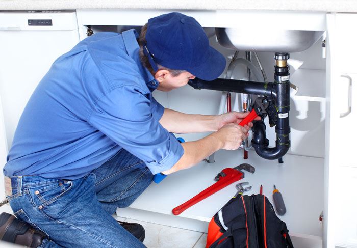 Plumber working on pipes
