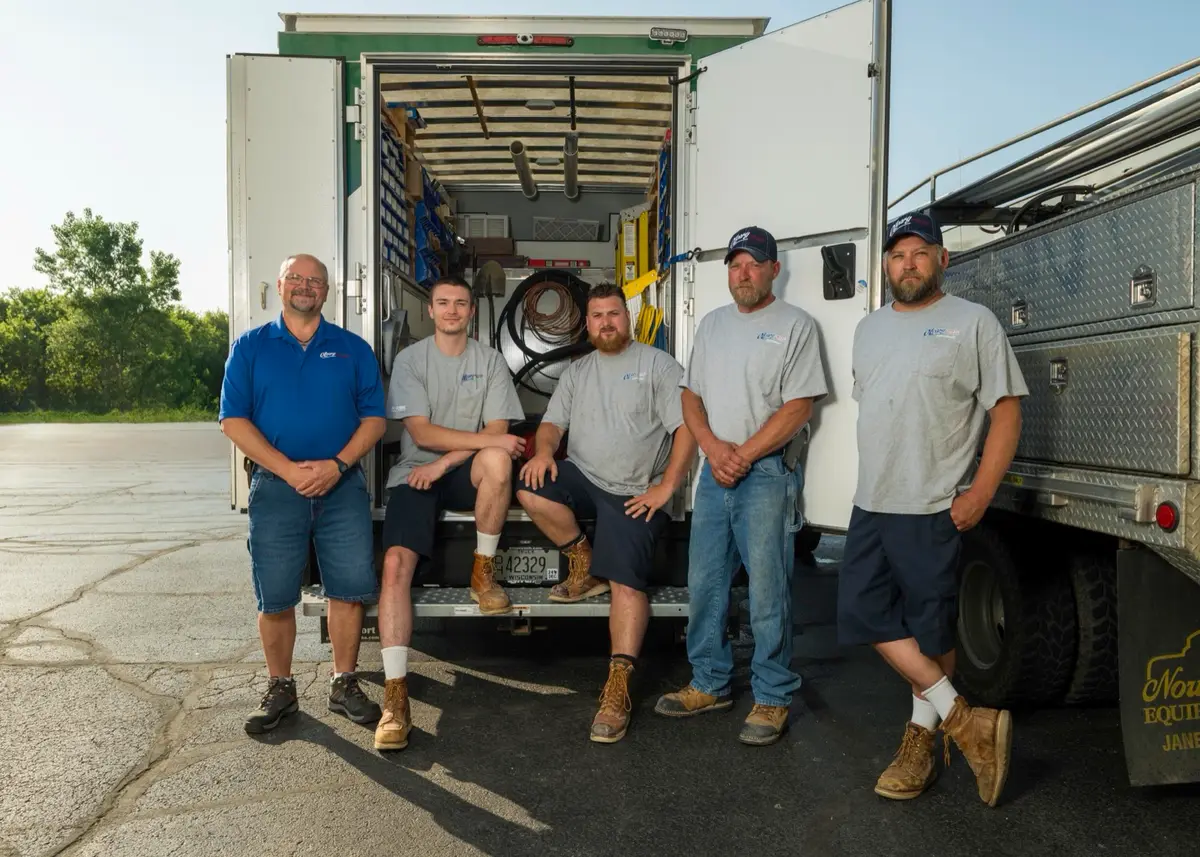 O'Leary plumbing construction team in front of branded service trucks